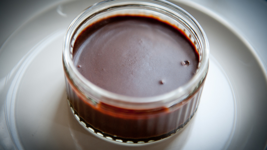 chocolate pudding in clear ramekin on white plate